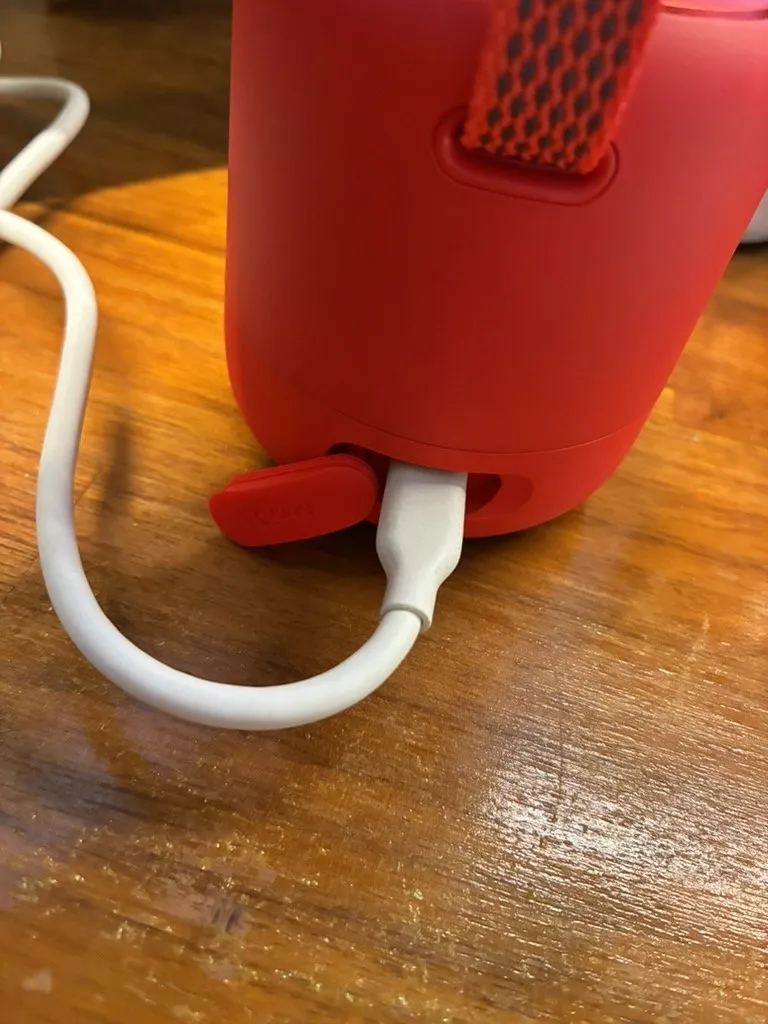 Soundcore Mini 3 のUSB-C端子にケーブルを挿した状態。シリコンのカバーが横に開いたまま固定されている