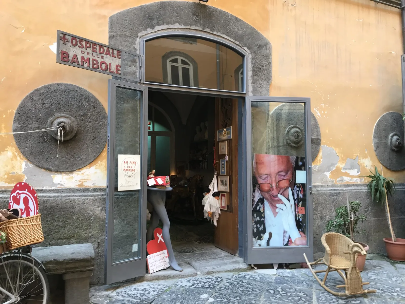 「OSPEDALE DELLE BAMBOLE(人形病院)」の看板が掲げられた店の入口